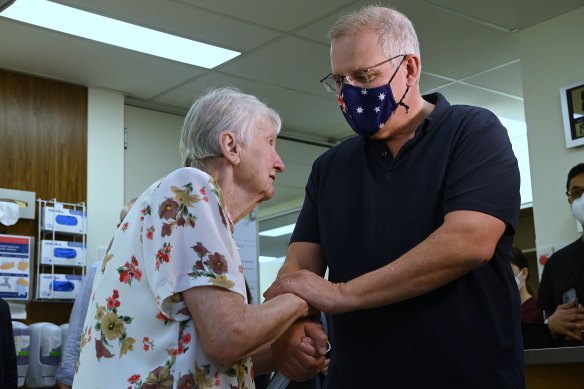 Prime Minister Scott Morrison greets Jane Malysiak before receiving their COVID-19 booster vaccinations at Kildare Road Medical Centre in Blacktown in Sydney.