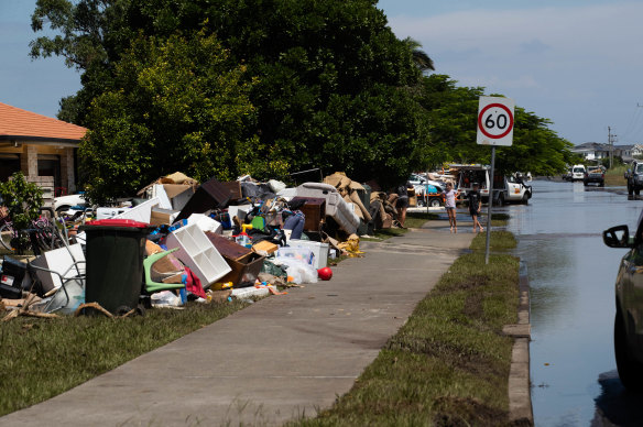Piles of flood-ruined belongings line the streets in Ballina, where residents are now eligible for additional disaster payments.