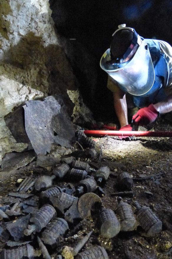 An explosive ordnance disposal  technician clears one of the 600 caves that contain grenades and other explosives on the island of Peleliu in the Republic of Palau.