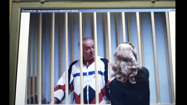 Sergei Skripal speaks to his lawyer from behind bars seen on a screen of a monitor outside a courtroom in Moscow in 2006.