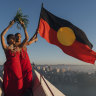 Abigail Delaney and Serene Dharpaloco Yunupingu from the Janawi Dance Clan, from the Darug nation, flying the Aboriginal Flag on top of the largest sail of the Sydney Opera House in 2019.