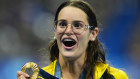 Kaylee McKeown reacts as she holds her gold medal for winning the women’s 100 metre backstroke final.