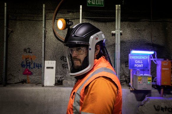A worker with a beard wears a full face mask to avoid breathing in dangerous dust particles while the new WestConnex interchange tunnel is under construction. The project is on target to be completed by the end of the year.