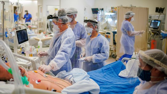 Health workers tend to a COVID-19 patient in the ICU ward at the Hospital das Clinicas in Porto Alegre, Brazil.