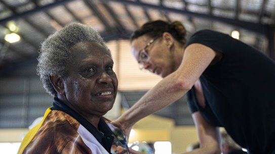 Rosie Gibuma receives a vaccination at the Boigu community centre from Queensland Health nurse Ruth Ferguson.