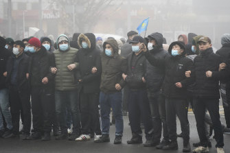 Demonstrators stand in front of police line during a protest in Almaty, Kazakhstan.