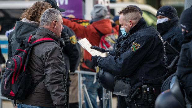 Police officers register one protester at a rally against coronavirus lockdown measures in Leipzig, Germany. 