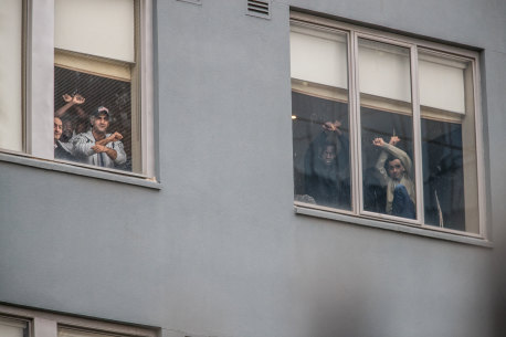 Some of the refugees and asylum seekers detained at the Mantra Hotel in Preston watch a protest on the weekend from a window.