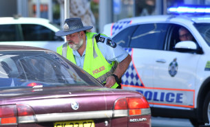 Police are seen stopping cars at a check point on the Queensland and New South Wales border on Griffith Street in Coolangatta at the Gold Coast on Friday.