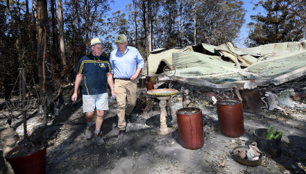 Property owner Stuart Skeen walks with Prime Minister Scott Morrison through his burnt-out property at Binna Burra in the Gold Coast Hinterland.