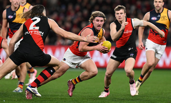 Sam Berry of the Crows runs with the ball under pressure.