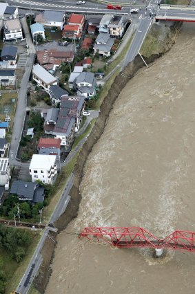 Surging waters from the Chikuma River in Ueda, Nagano Prefecture threaten homes in central Japan. 