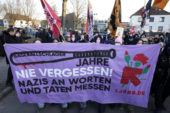 Protesters hold a banner saying “Never Forget” outside the far-right AfD party offices in Berlin on Sunday.