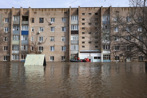 Russian Emergency Ministry employees ride a boat along a flooded street in Orenburg, Russia.