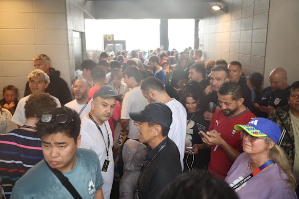 Fans seek shelter during the rain delay at Philadelphia Stadium.