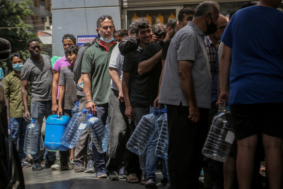 People wait in line at a petrol station in Beirut amid fuel shortages. 