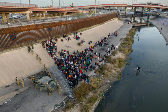 Texas National Guard troops block migrants from entering a high-traffic border crossing area along Rio Grande in El Paso, Texas.