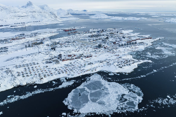 Houses covered in snow are seen on the coast of a sea inlet of Nuuk, Greenland, on Friday.