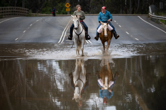Mooroopna locals ride to Shepparton to buy bread after the small town was cut off by the floods. 