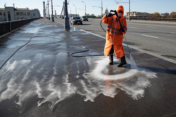 A worker cleans and disinfects Garden Ring in Moscow, almost empty of pedestrians, during the coronavirus lockdown.