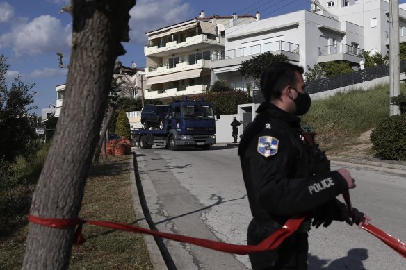 A police truck carries the car of veteran Greek crime reporter Giorgos Karaivaz, who was gunned down in southern Athens.