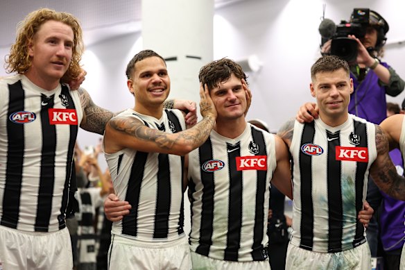 Teamgenoten tonen hun zorg voor Lachie Schultz terwijl de Magpies hun teamlied zingen na de overwinning van donderdagavond.