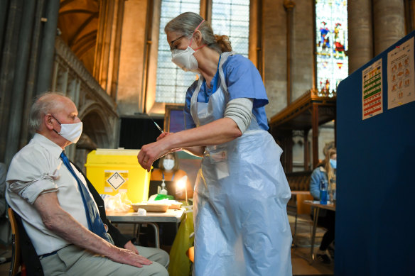 An English patient receives a dose of the Pfizer vaccine inside Salisbury Cathedral