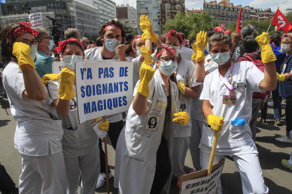 Yellow gloves: Medical staff hold a placard reading "there is no magical medical staff" during a demonstration in Paris last week, referring to President Emmanuel Macron who said "there is no magical money for hospitals".