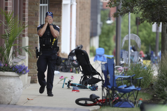 A Lake County police officer walks down Central Ave in Highland Park after the shooting.