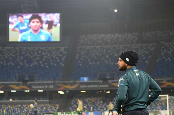 Napoli's Lorenzo Insigne looks on as a picture of Maradona is beamed to an empty Stadio San Paolo before the Europa League clash with HNK Rijeka.