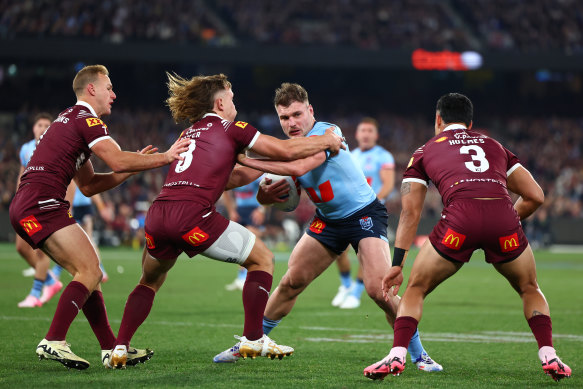 Angus Crichton of the Blues is tackled by Reuben Cotter of the Maroons.