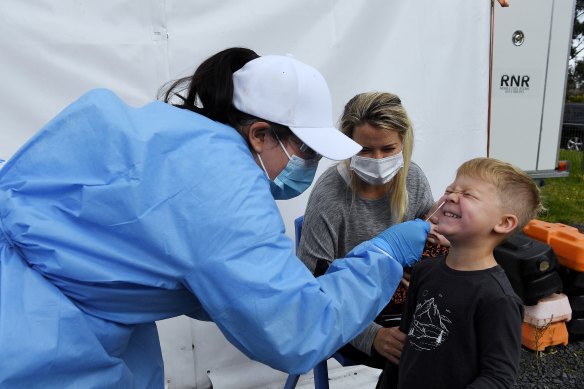 Clinical Labs pathology collector Laura Benavides carries out a COVID-19 test on Hudson Disher, 4, watched by his mother Laura McGregor at Hornsby Clinical Labs pathology drive-through clinic. 