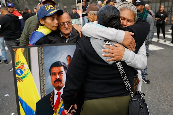 Supporters of Venezuelan President Nicolas Maduro embrace in downtown Caracas on Saturday.