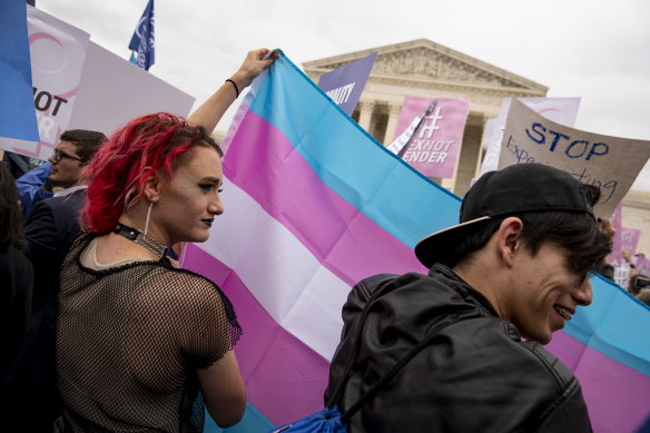 Demonstrators hold up a transgender flag outside the Supreme Court in Washington.