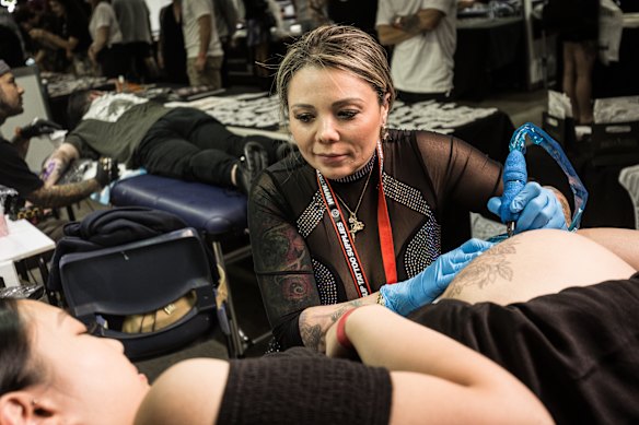 Tattoo artist Karlla Mendes with client 'Anne' at the Australian Tattoo Expo.