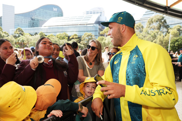 Grae Morris lends his Olympic silver medal to a fan at Tumbalong Park on Friday afternoon.