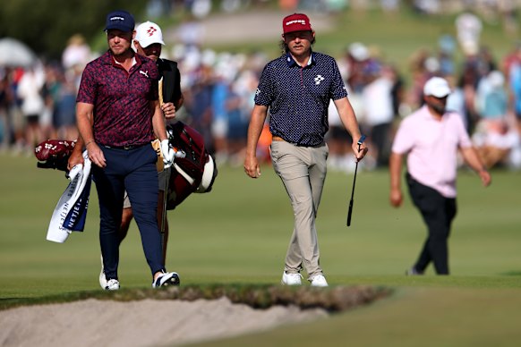 Danny Willett of England and Cameron Smith of Australia walk on the 18th hole.