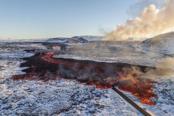 A view of lava crossing the main road to Grindavík and flowing on the road leading to the Blue Lagoon, in Grindavík, Iceland.