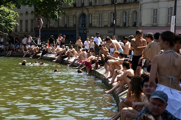 I frequentatori del festival fanno un tuffo nel Canal Saint-Martin tra un concerto e l'altro alla Fete de la Musique 2026 a Parigi.