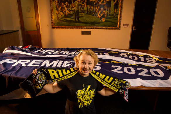 Richmond supporter and AFLFA president Cheryl Critchley with the premiership flags from 2019 and 2020.