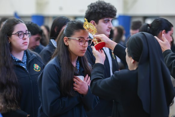 A nun blesses an Antonine College student with one of St Carlo’s reliquaries.