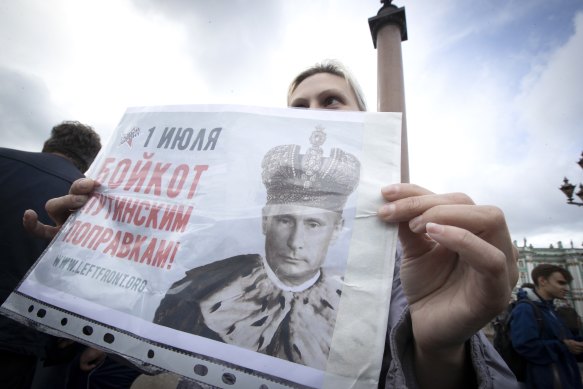 A woman holds a poster reading "July 1. Boycott of Putin's amendments" protesting on Palace Square in St. Petersburg, Russia, on Wednesday.