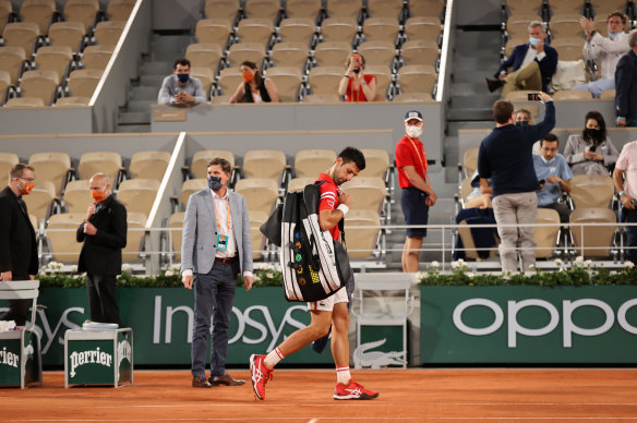 World No.1 Novak Djokovic leaves the court after play was suspended during the fourth set of his French Open quarter-final.