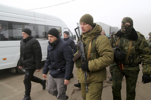 Ukrainian war prisoners escorted by armed Russia-backed separatist soldiers walk to buses to be exchanged at a checkpoint near Horlivka, eastern Ukraine.