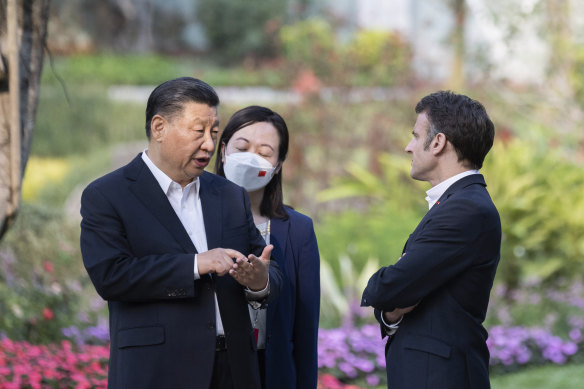Chinese President Xi Jinping and French President Emmanuel Macron talk in Guangzhou. 