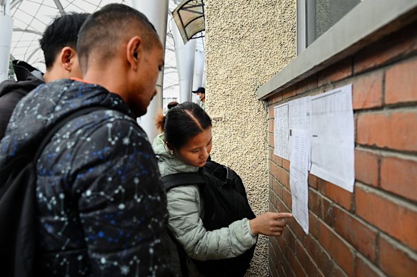 A woman searches a list of survivors who are being treated at the TU Teaching Hospital in Kathmandu, Nepal.