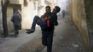 Members of the Syrian Civil Defence group known as the White Helmets carry a man who was wounded during airstrikes in Ghouta.