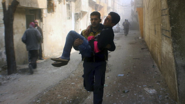 Members of the Syrian Civil Defence group known as the White Helmets carry a man who was wounded during airstrikes in Ghouta.