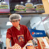 Fast food workers at Chinese burger chain Tastien prepare orders at a store in Beijing.