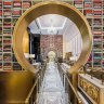 A book lounge features striking custom shelving stacked with 4000 hand-picked books.